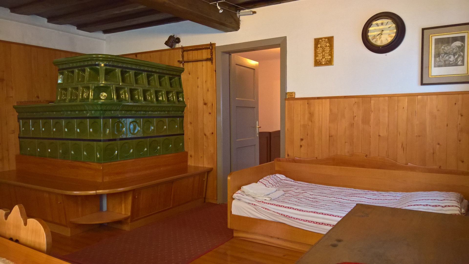 The living room has a large stove that warms the house during cold winters.